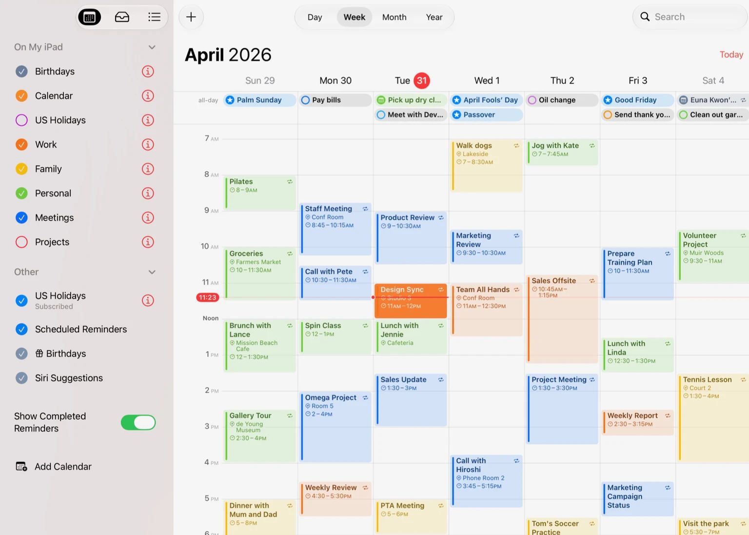 Calendrier d'Apple sur iPad, interface en anglais, semaine du 29 mars au 4 avril 2026 : calendriers de couleur dans la barre latérale avec l'option d'affichage des rappels terminés, rappels et événements de la journée entière en haut, événements de couleur au fil des heures.